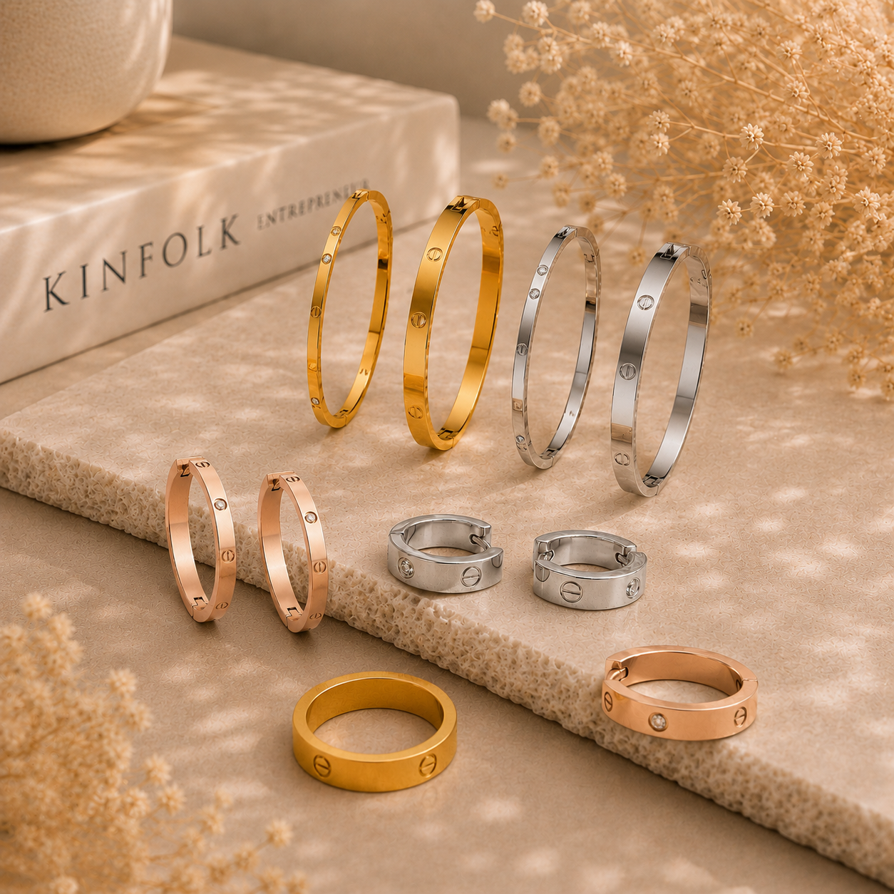 Luxury-inspired stainless steel jewelry set featuring gold, silver, and rose gold bangles, rings, and hoop earrings with screw and crystal details.